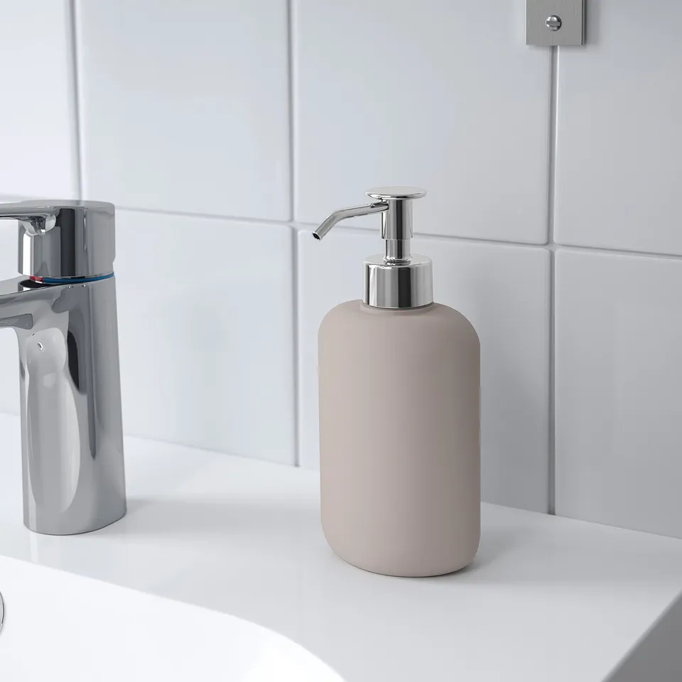 A soap dispenser on a sink, part of the EKOLN series, easy to fill with soap, coordinating with other bathroom accessories.