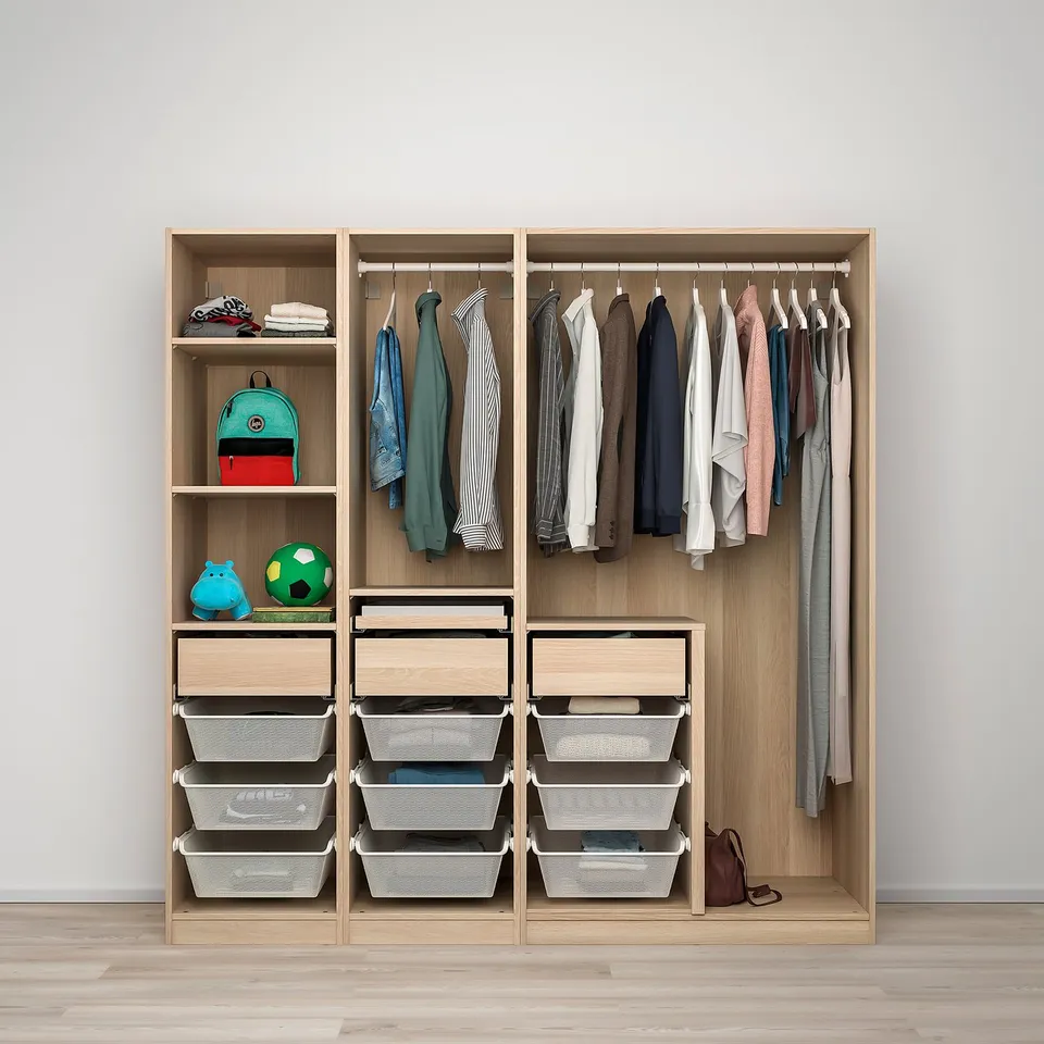 A kids wardrobe with a hanging rod for clothes, shelves for toys, and drawers with mesh baskets for folded clothes.