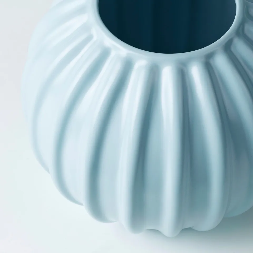Light blue glazed stoneware vase with smooth, fluted design.