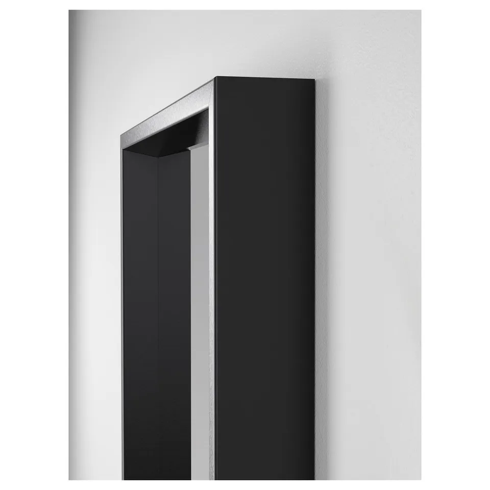 Black framed mirror mounted on a light wall. Sharp, sleek edges and clear reflection. High-quality, modern design.