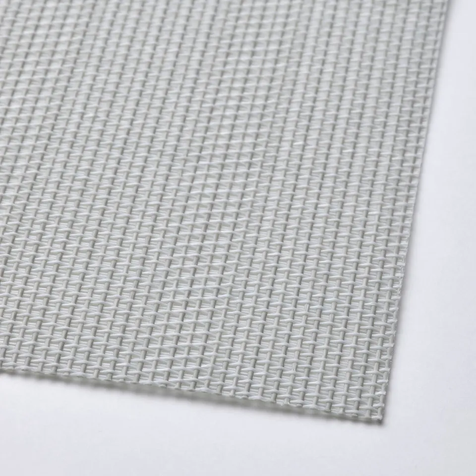 Textured, light-colored woven plastic place mat. Intricate, uniform pattern visible.