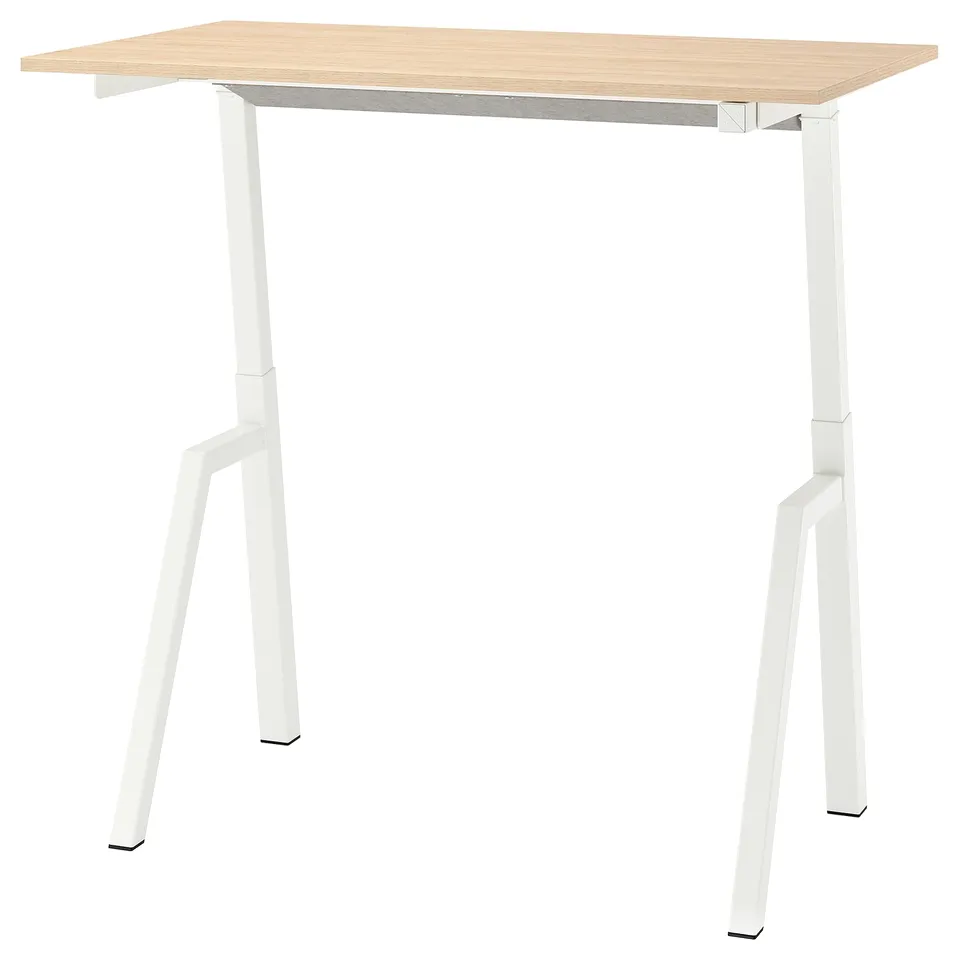 A TROTTEN modern standing desk with a light brown top and white legs.