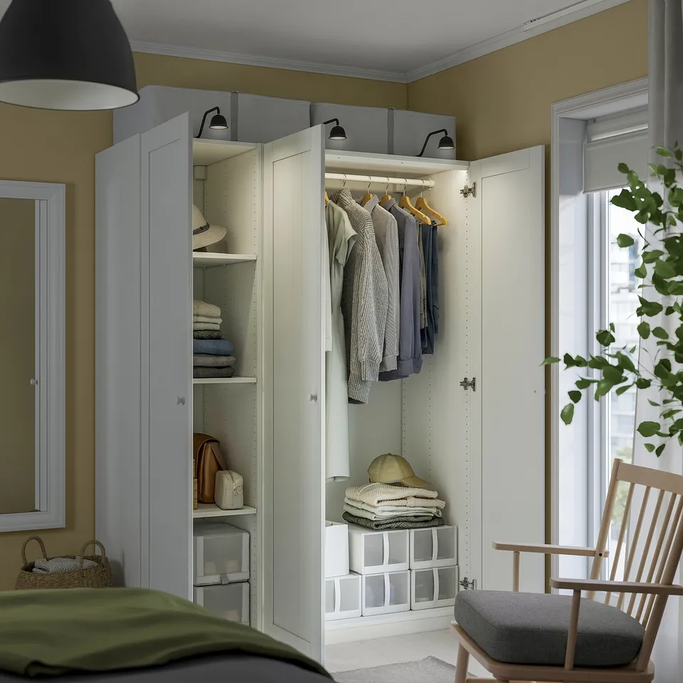 Cosy bedroom with PAX closet, neatly organised. Green blanket on bed, rocker with cushion, large window for natural light.