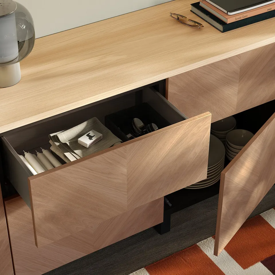 Light wood BESTÅ drawer open, revealing cutlery and plates.