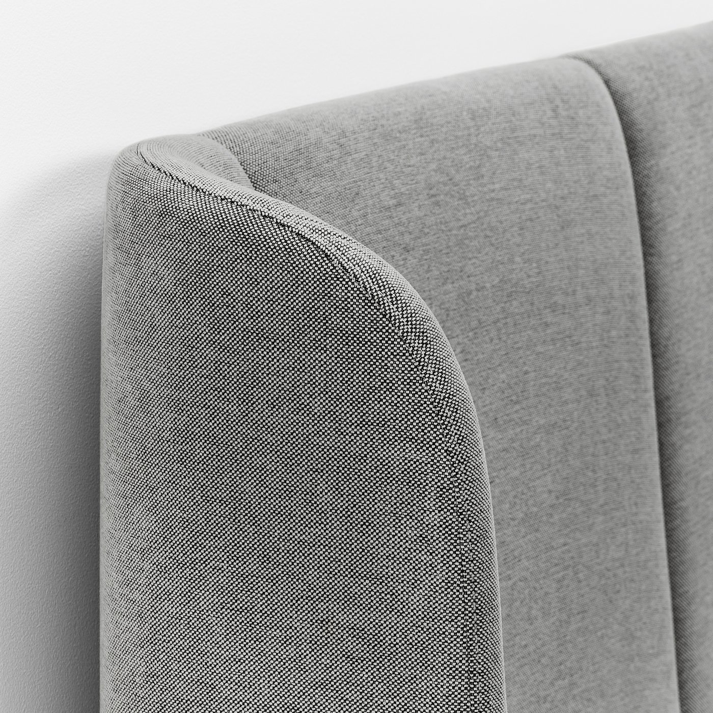 Close-up of TUFJORD beds upholstered headboard, showcasing plush, textured fabric and sleek stitching, highlighting durability and comfort.