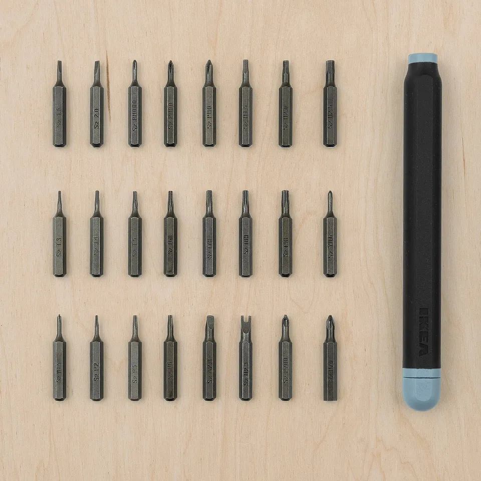 Set of 24 black TRIXIG precision screwdrivers laid out on wood, with a black and blue magnetic handle. Various shapes and sizes for detailed work.