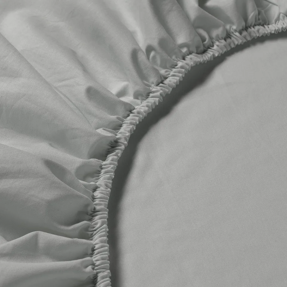 Close-up of soft, pure cotton fitted sheet showcasing elastic detailing for a secure fit.