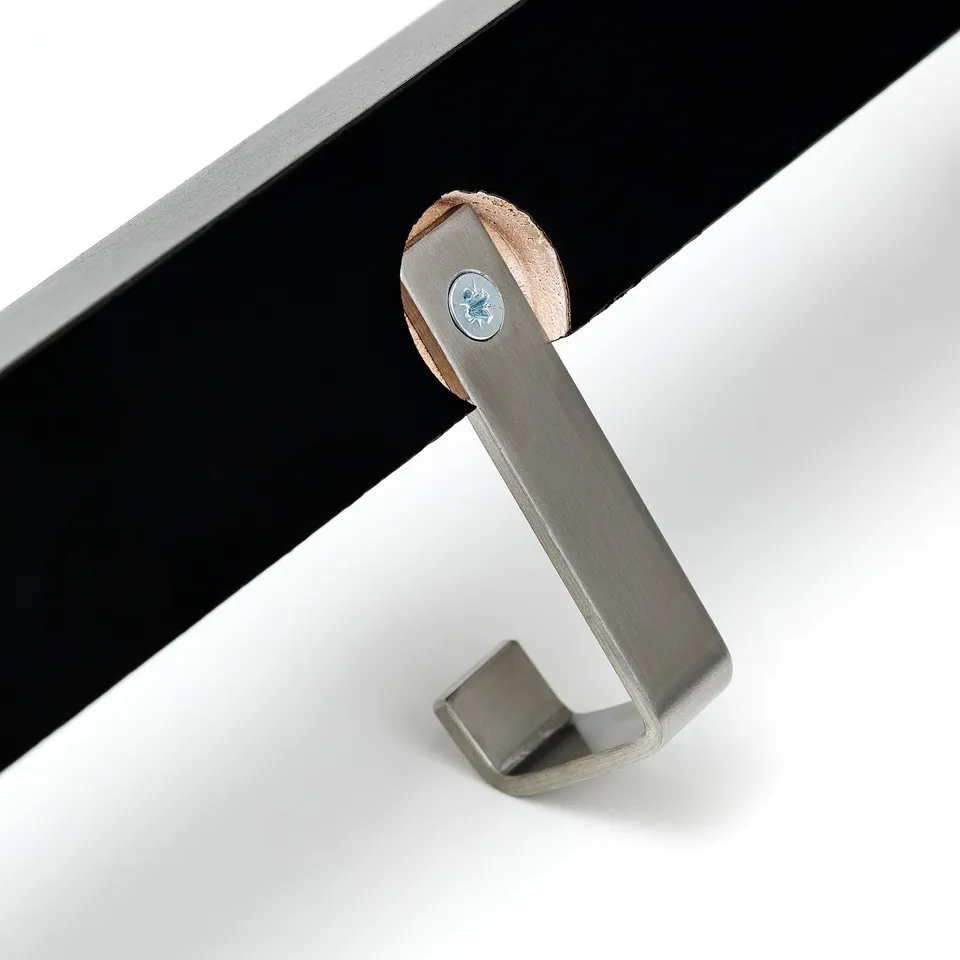 A modern coat hook with a sleek stainless steel hook and a stylish wooden base.
