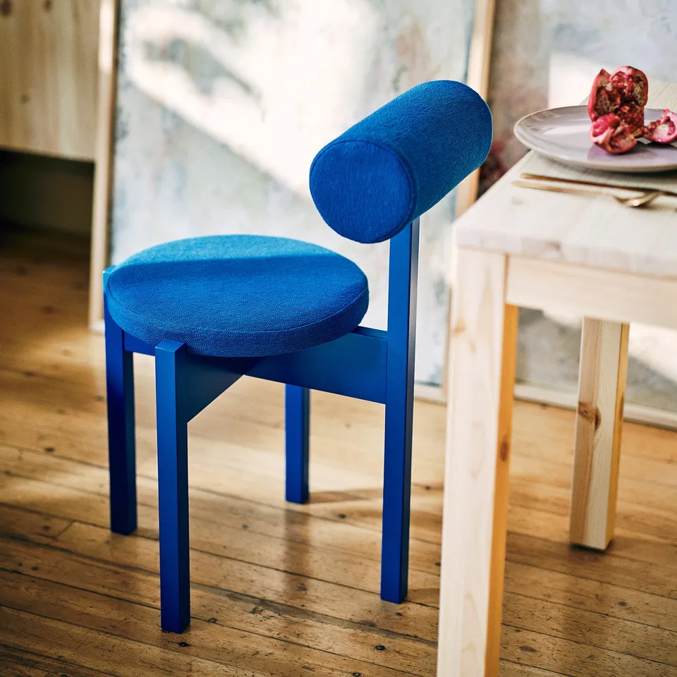 Blue round chair with cylindrical back, ergonomic, padded.