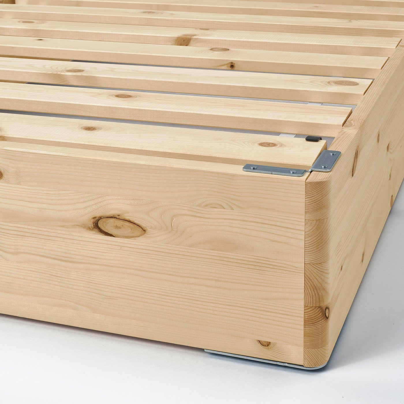 Close-up of LYNGÖR wooden bed frame, showing sturdy, interconnected pine slats and metal support brackets, ensuring durability and support.
