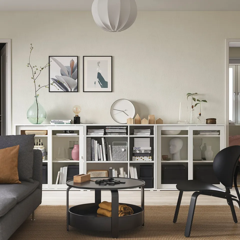 Modern living room with grey VIHALS bookshelf, sliding doors, decor items, black furniture, and artwork.