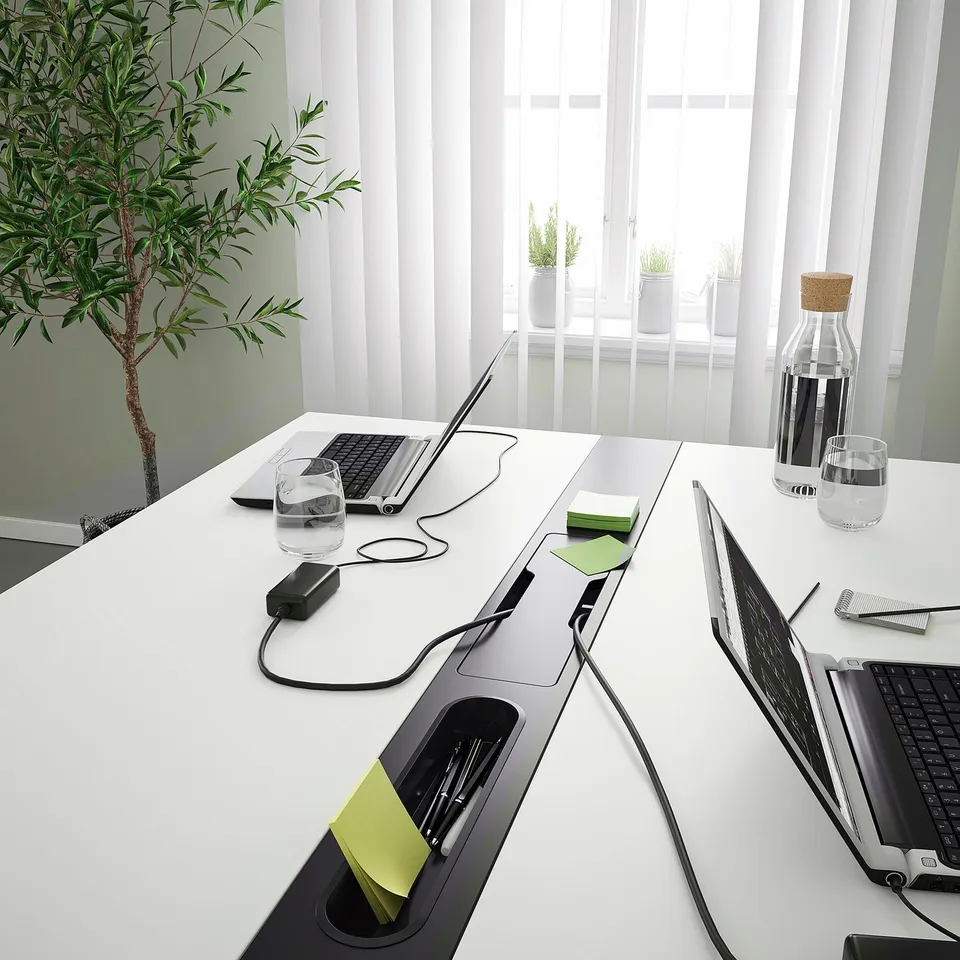 Conference table with built-in cable management and hooks for organisation, suitable for shared workspaces.