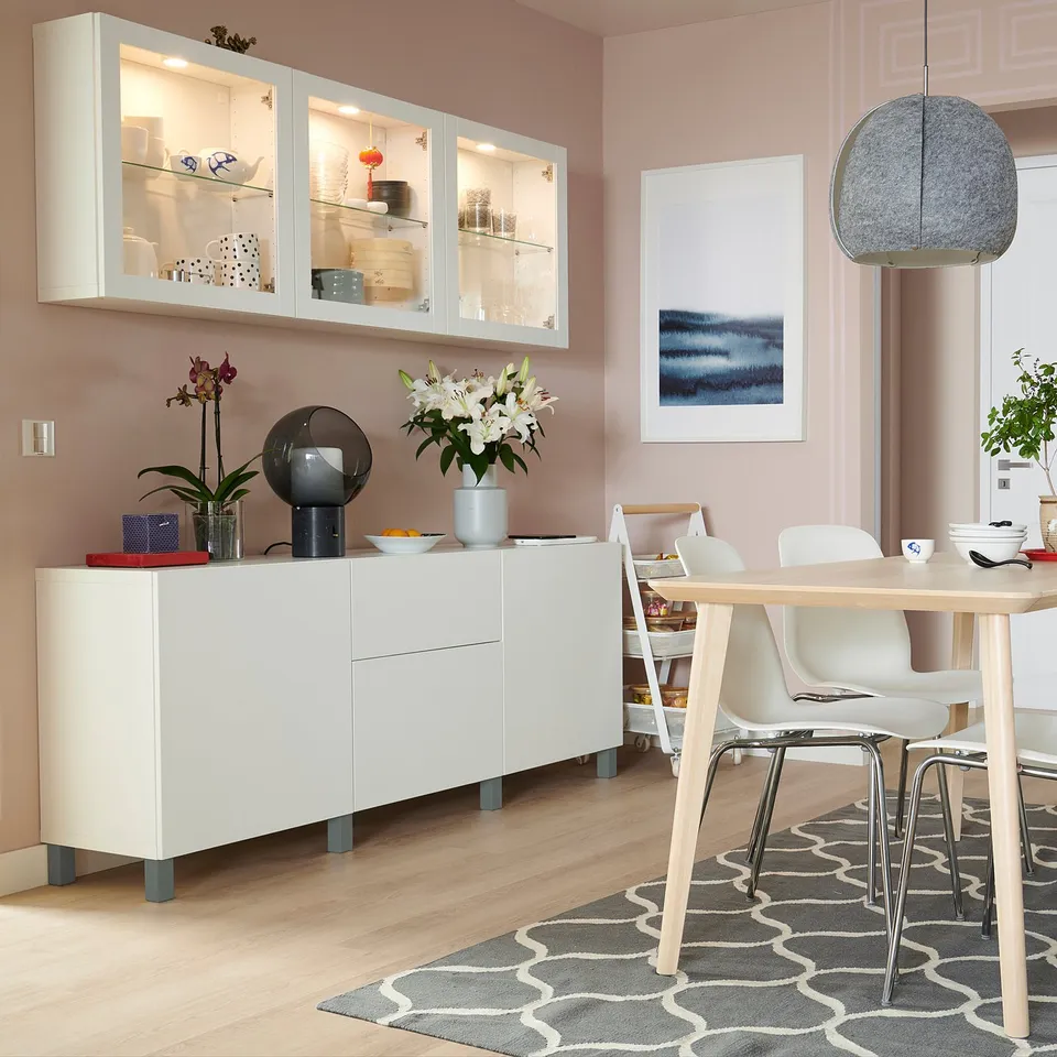 Modern dining room with white STUBBARP legs on storage unit, light wood table, and grey patterned rug.