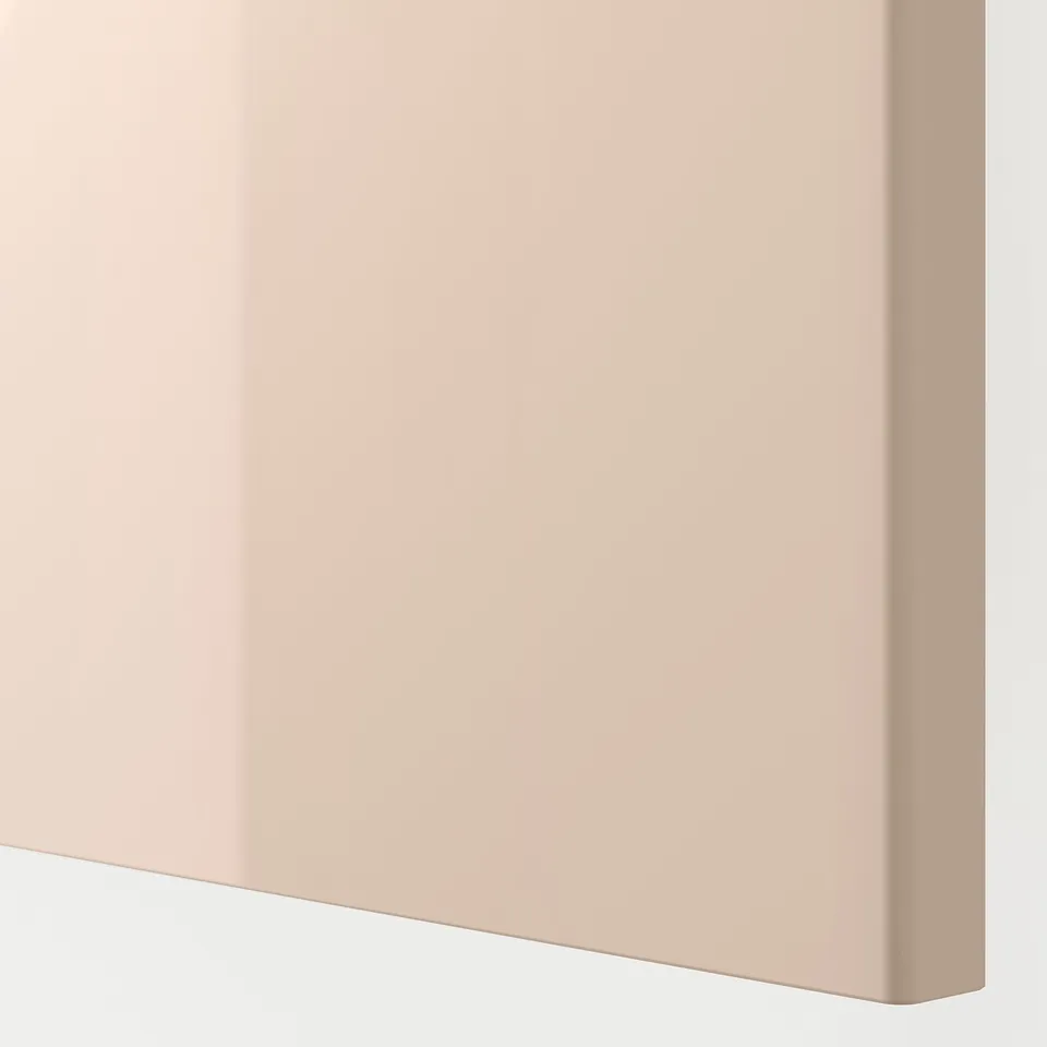 A close-up of a smooth, high-gloss, light-orange cabinet door with bevelled edges.