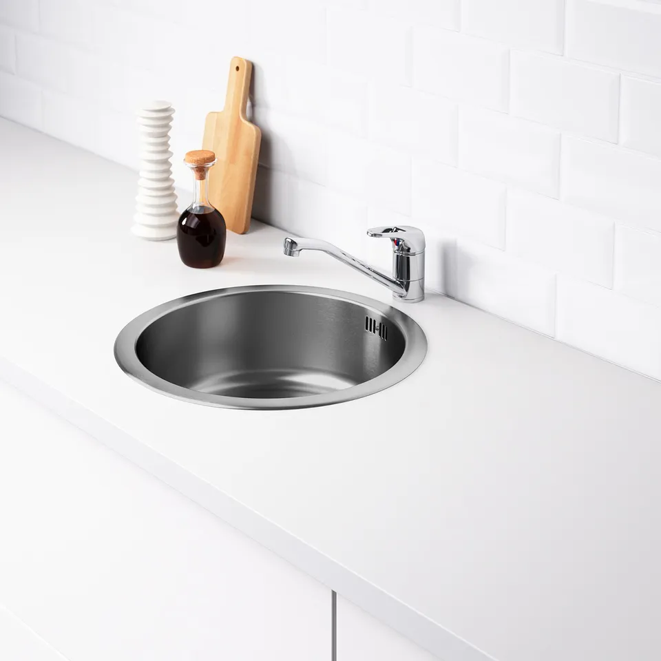 Stainless steel sink with tap on white countertop. Includes sound-absorbing material under the sink to reduce noise.