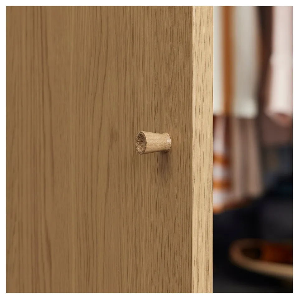 Wooden drawer with cylindrical handle, showcasing light brown finish and clean design.