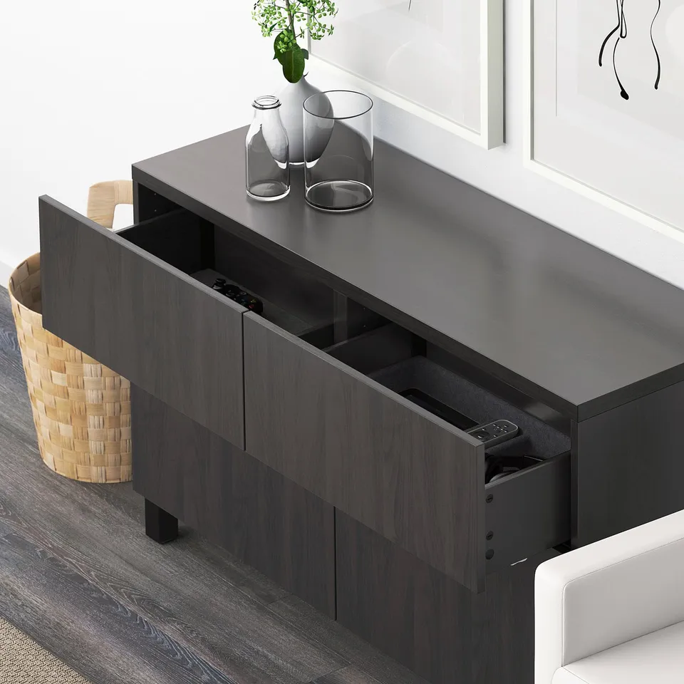 Dark sideboard with drawers open, displaying remote control holder and other compartments. Vases on top.