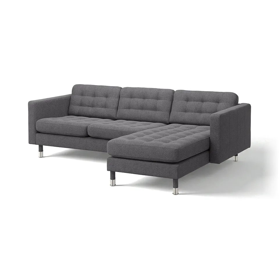 Modern dark grey l-shaped sofa with tufted cushions and chrome legs.