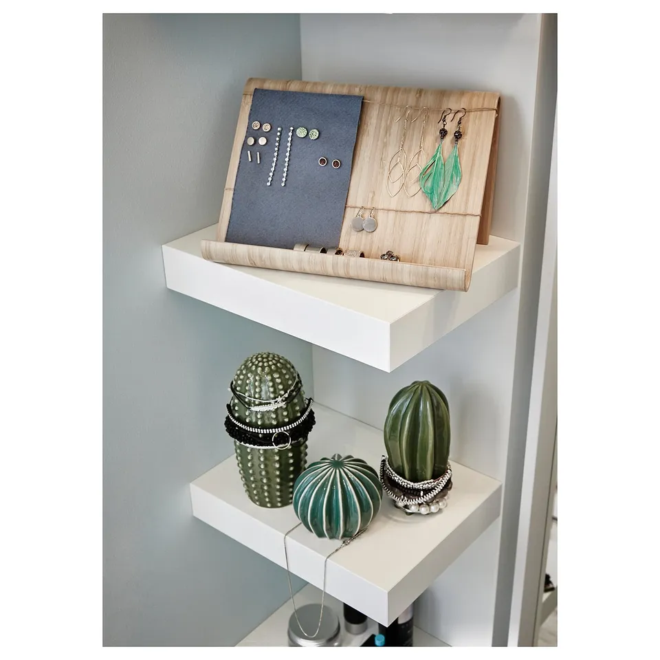 White shelves holding jewellery tray and 3 green ceramic cacti.