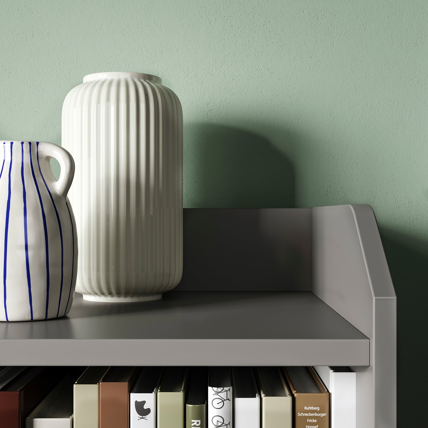 Two vases on a grey shelf against a green wall. One white, ribbed vase and one white vase with blue stripes. Modern, minimalist design.