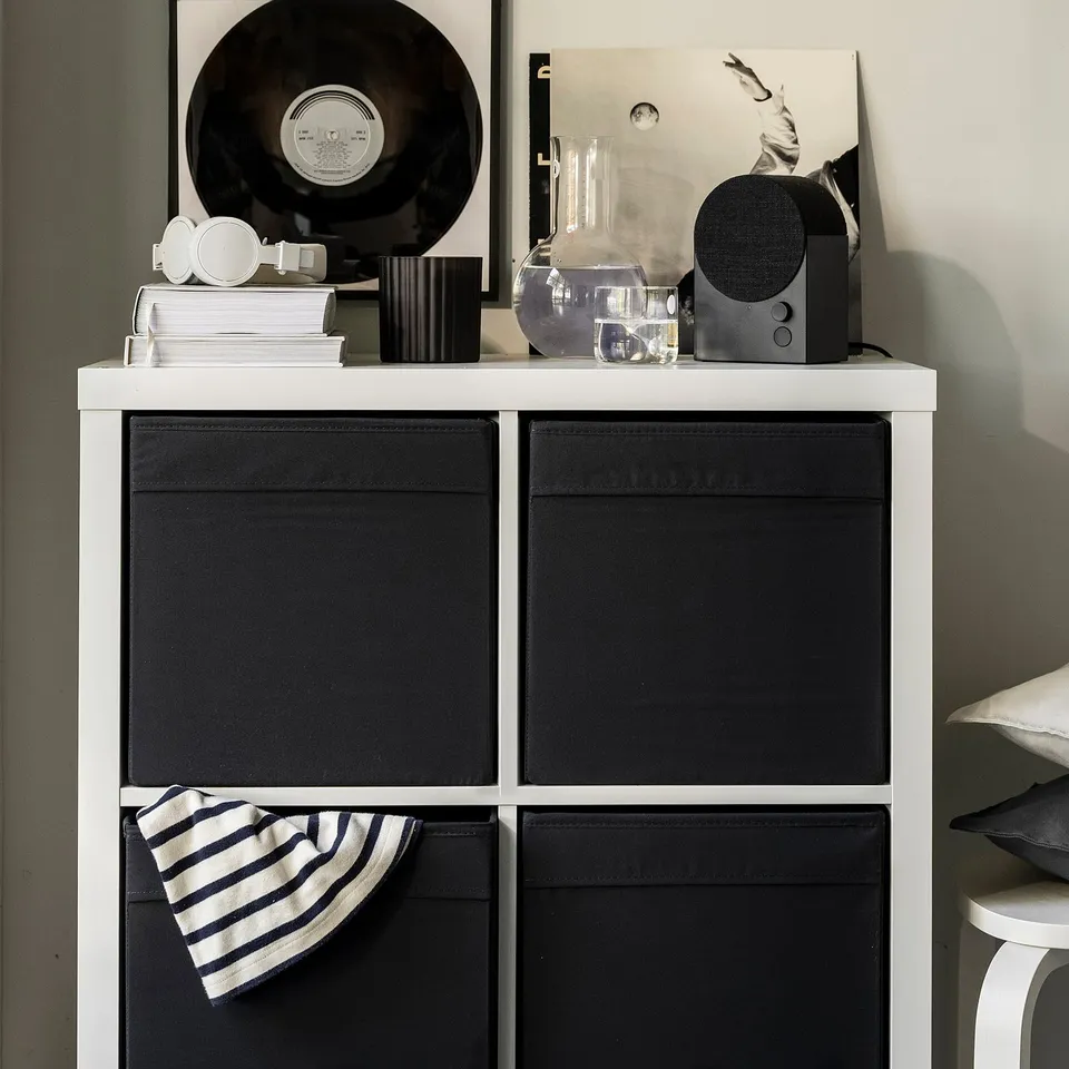 DRÖNA black storage box with handles, medium-sized, fits kallax shelf, among books and decor.