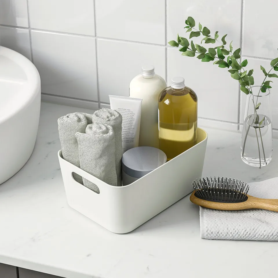 Bathroom organiser with towels, bottles, and brush, featuring handles for portability and easy access.