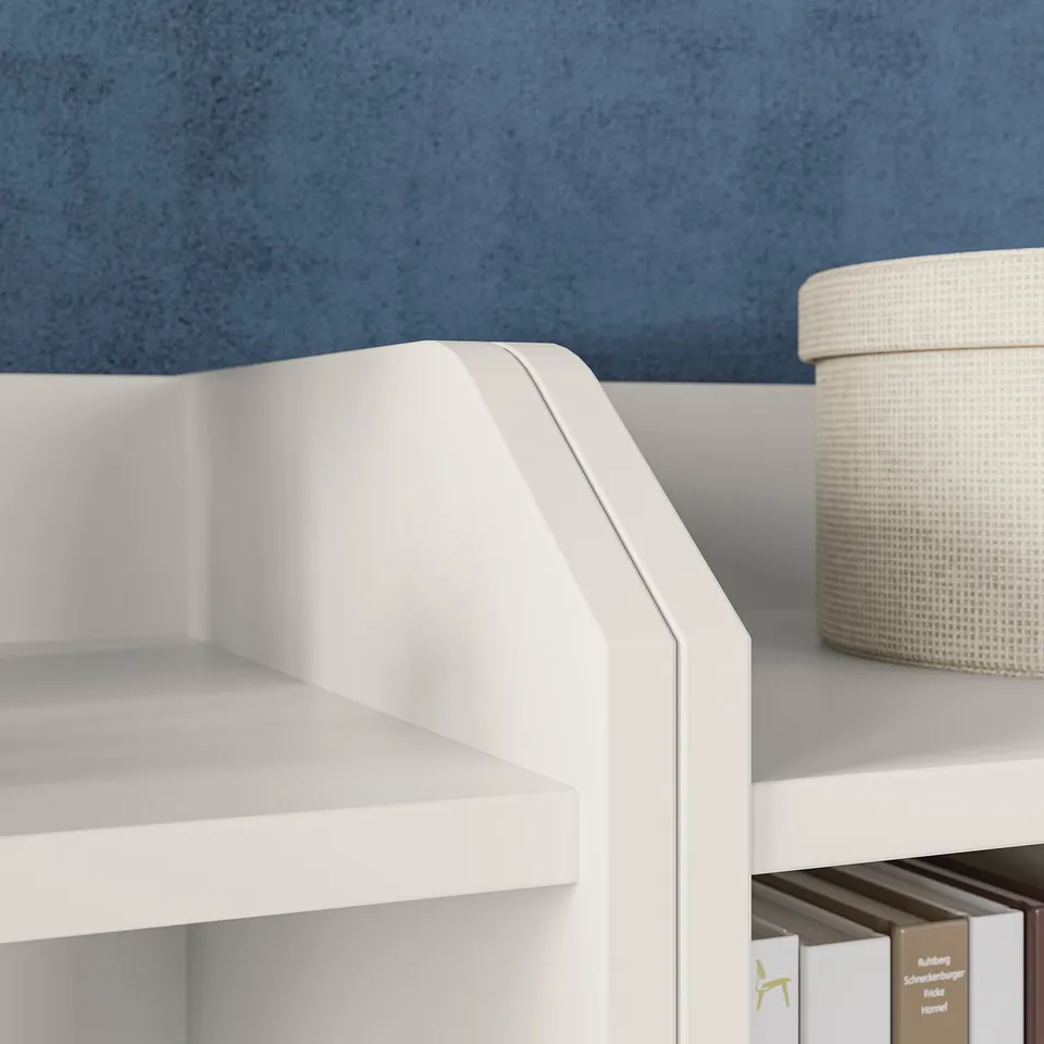 White HAUGA storage unit with shelves and basket against blue wall.