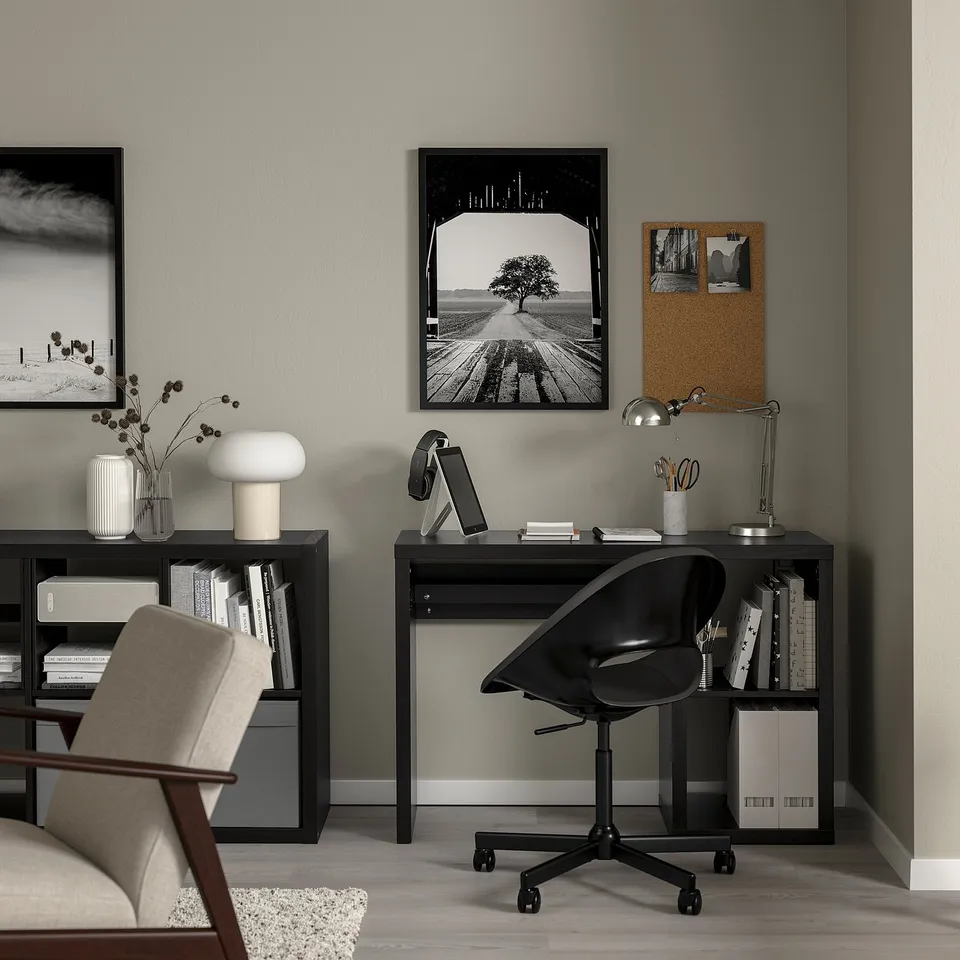 Black KALLAX home office with minimalist desk, chair, shelves, and wall art.