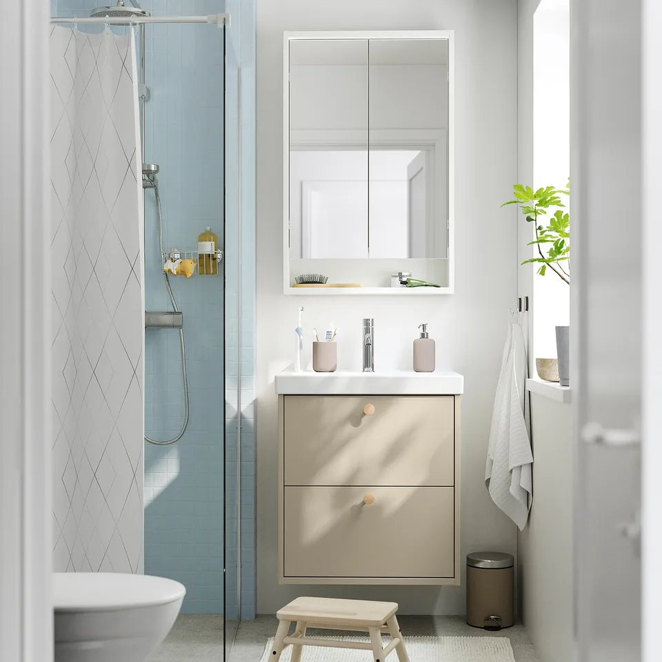 Modern bathroom with beige vanity, drawers, white basin, mirror cabinet, blue tiles, curtain, and stool.