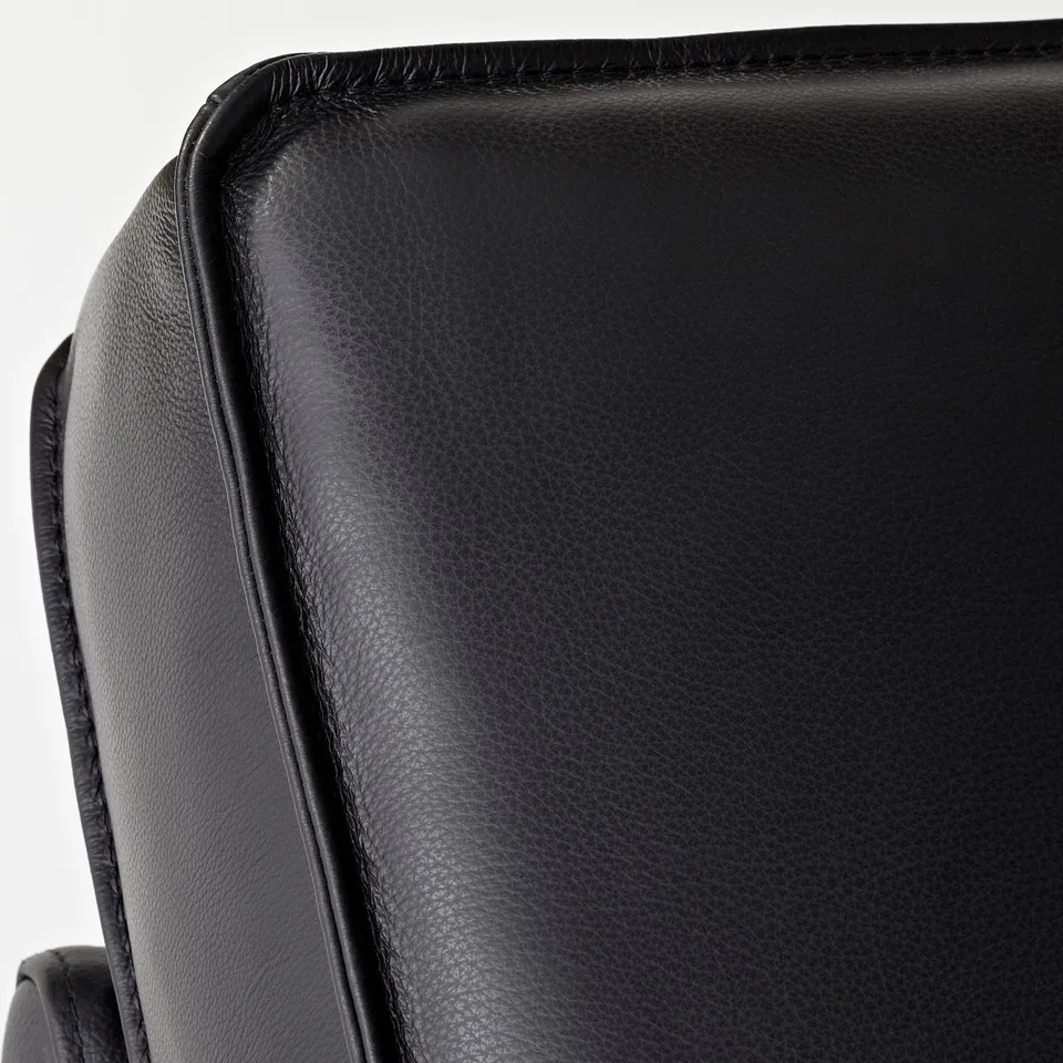 Close-up of KIVIK sofas smooth, high-quality black leather. Showing stitching detail and texture.