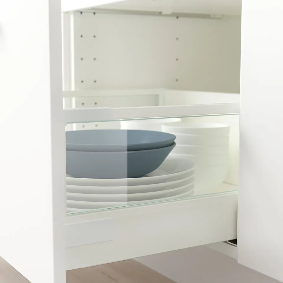 Glass-sided drawer organiser, holding plates and bowls.