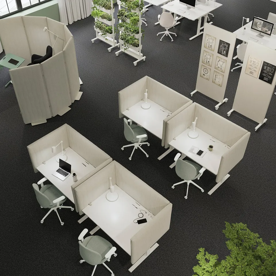 Modern office with MITTZON height-adjustable desks in pods, green chairs, lamps, plants.