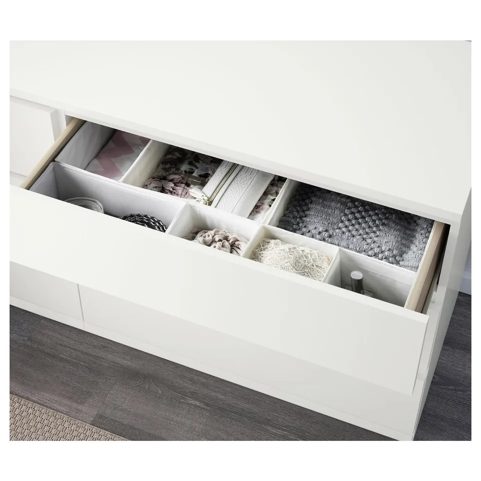 Open white chest of 6 drawers showing organised clothes and accessories in sections.