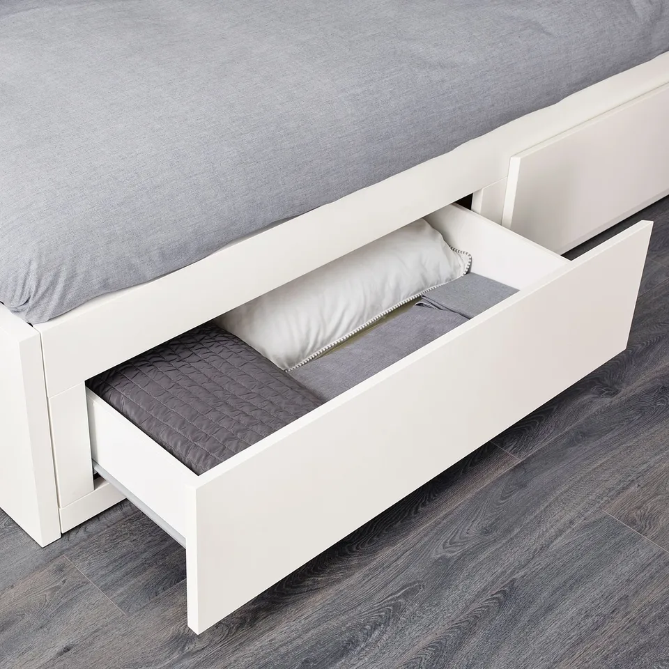 White daybed with open storage drawers for mattresses and linens.
