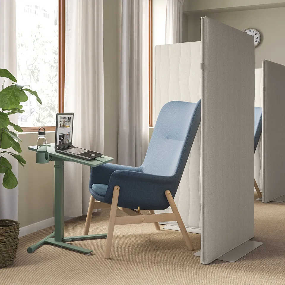 Modern office setup with MITTZON laptop table, blue chair, grey partition, and green desk near window.