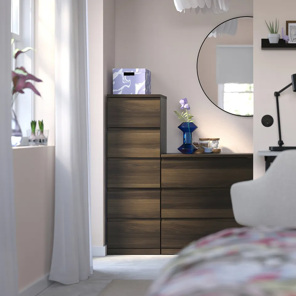 Wooden STORKLINTA chest with dark brown finish and purple box, tall and elegant.