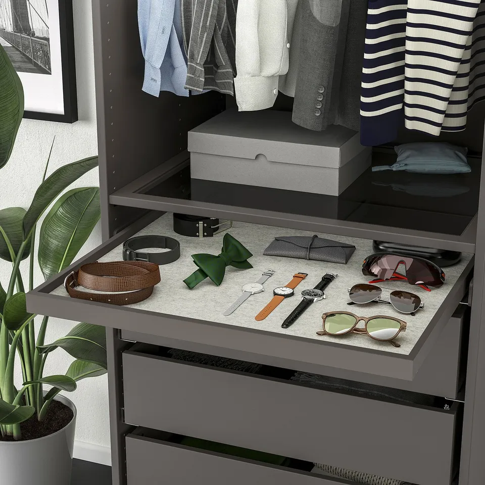 Wardrobe with pull-out accessory tray and felt mat. Clothes hang neat above.