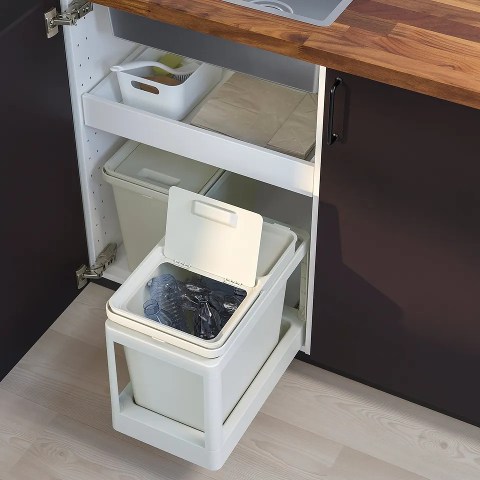 A white HÅLLBAR waste sorting bin under a kitchen cabinet, with a pull-out frame and a lid.