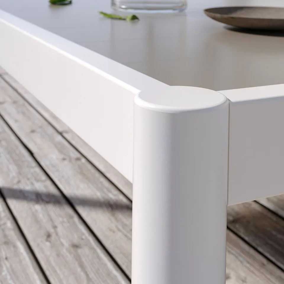 Modern white outdoor table leg with cylindrical shape and smooth finish on wooden deck.