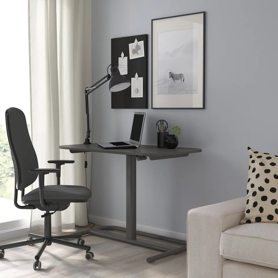 Modern home office with SEGRARE desk, grey chair, white armchair, light grey wall, decor, clean design.