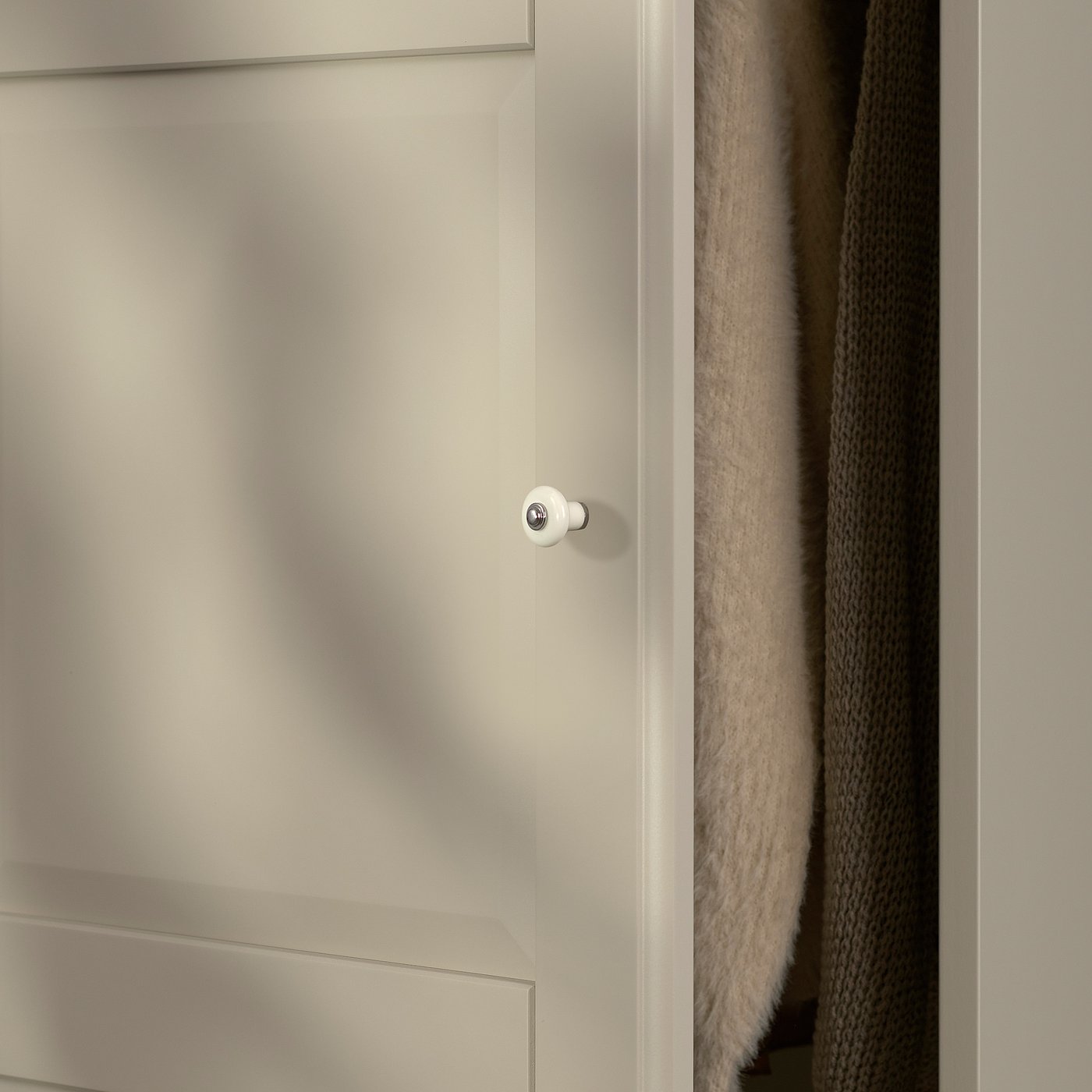 Close-up of TYSSEDAL cabinet door, smooth grey-beige finish with circular handle.