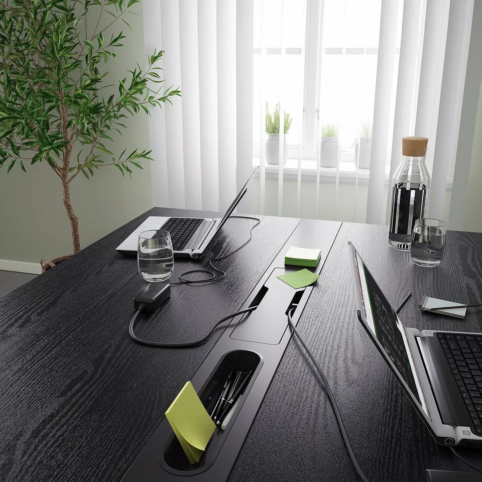 A modern conference table with integrated cable management and personal hooks, perfect for meetings or individual work.