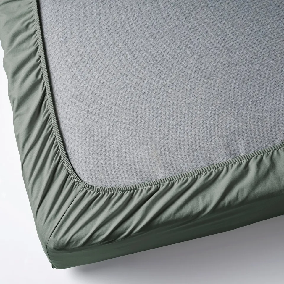 Gray-green fitted sheet with elastic edges for mattresses up to 26 cm thick.