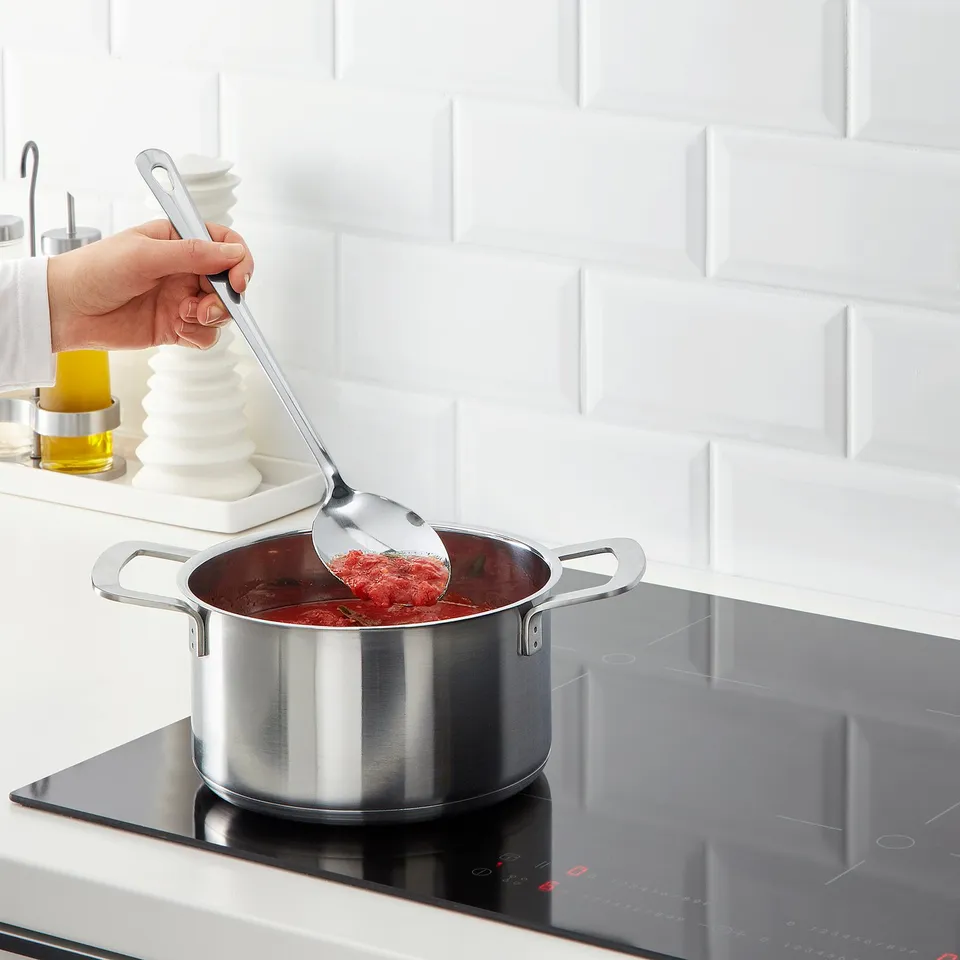 Stirring red sauce on modern stove.