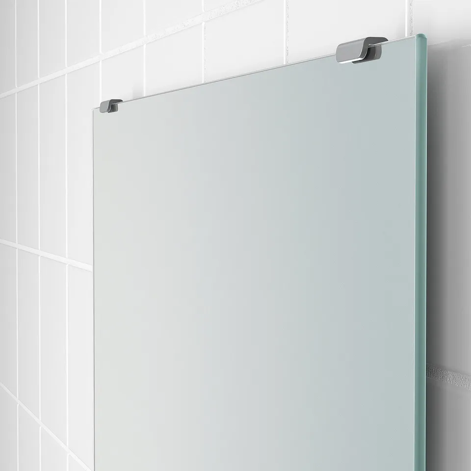 Modern bathroom mirror with sleek metal fixtures, securely mounted on tiled wall.