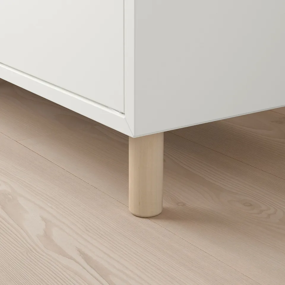 White cabinet with wooden leg; minimalist design.