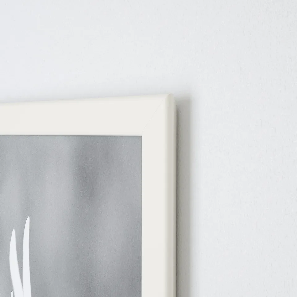 White picture frame corner on grey wall. Shows sleek design, secure hold, modern decor.
