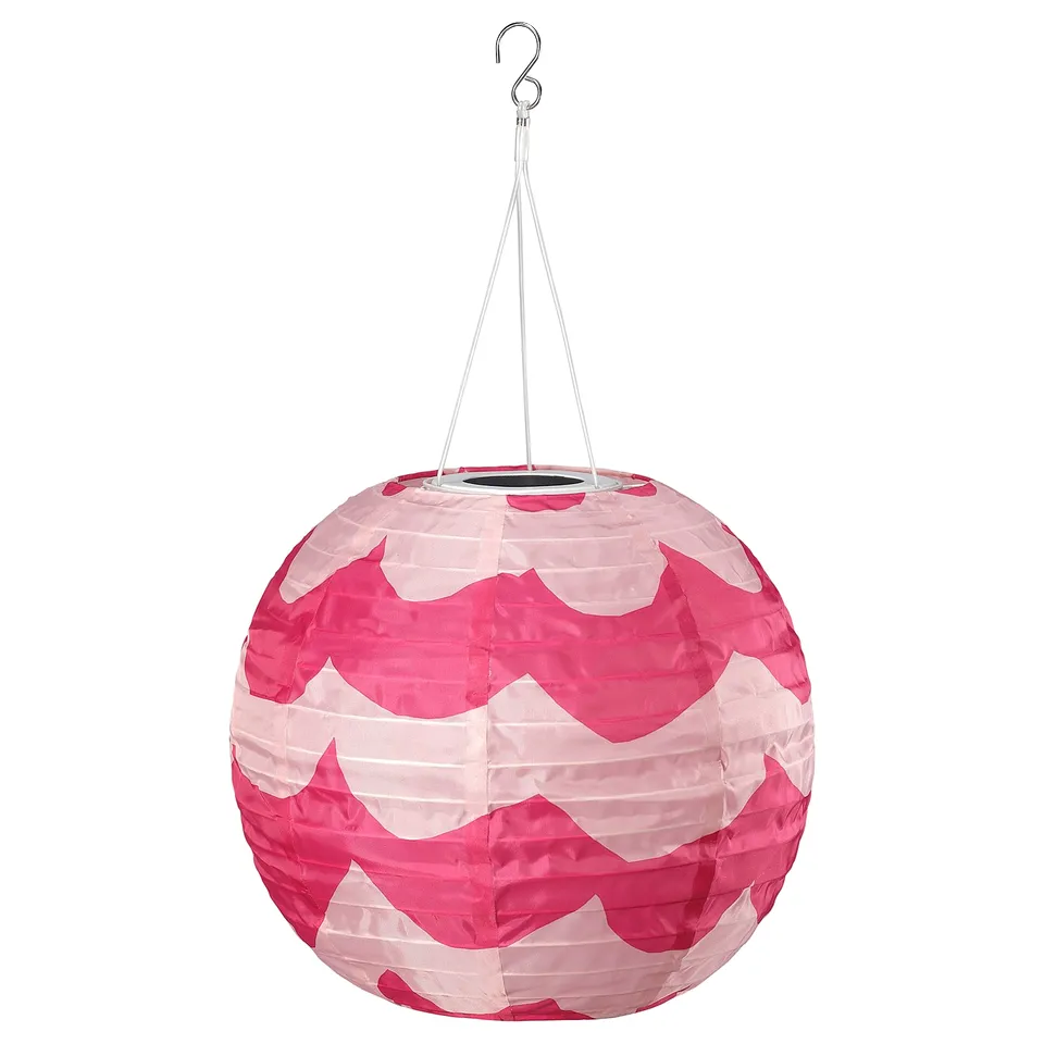 Bright pink and white zigzag lantern hangs from a hook, eco-friendly with solar power.