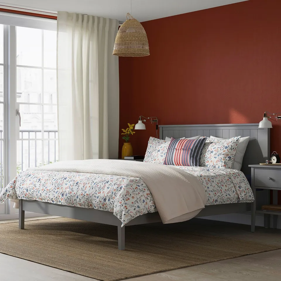 Cosy bedroom with grey GULLABERG bed and red wall. Large window with sheer curtains.