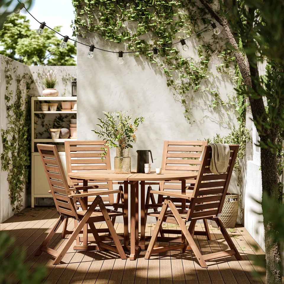 Outdoor patio set with round table and four wooden chairs, brown colour.
